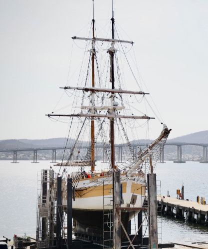 The Lady Nelson timber vessel at the Hobart slipyard with the Derwent bridge in the background